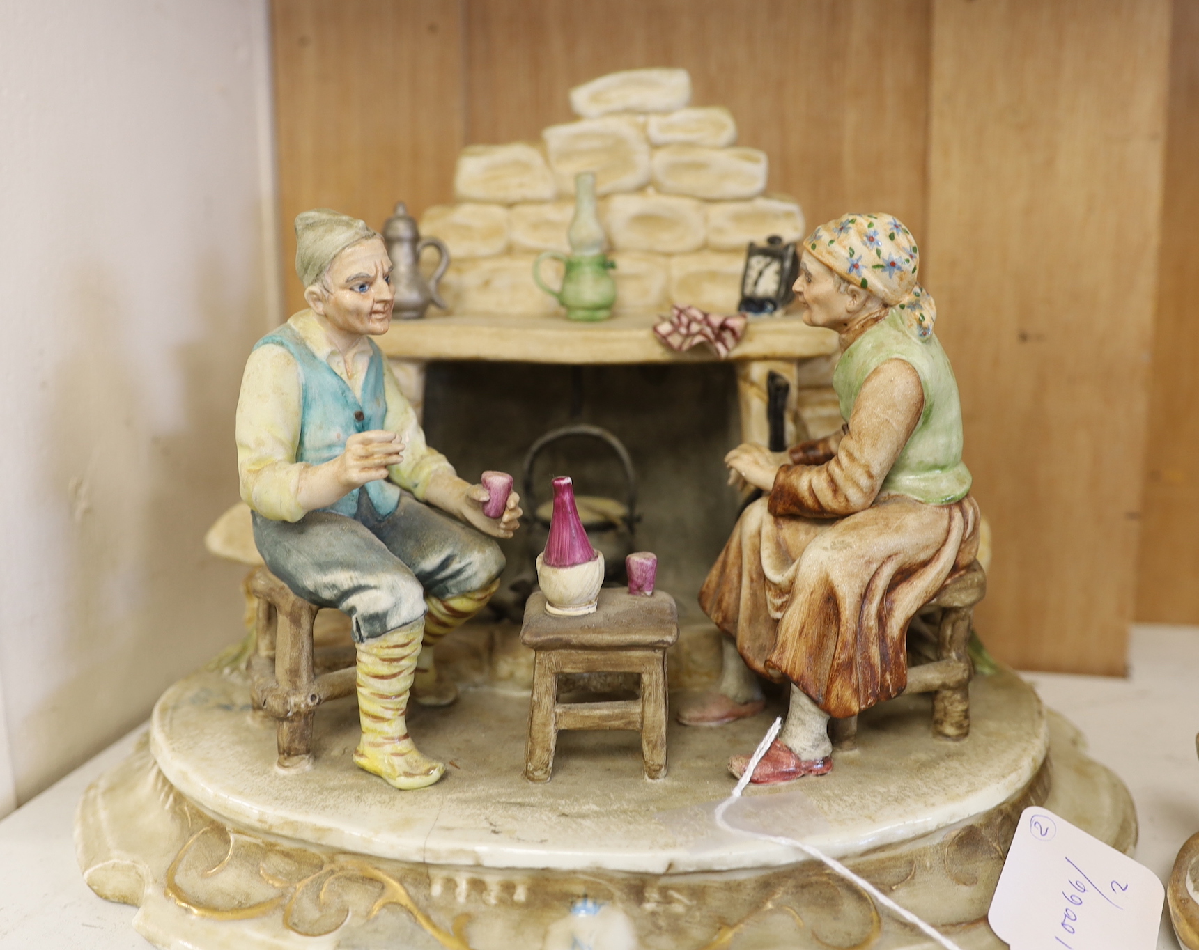 A Capo di Monte figure group of peasants by a fire and a cobbler